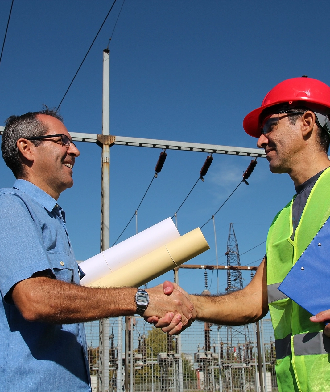Two men shaking hands at construction site.